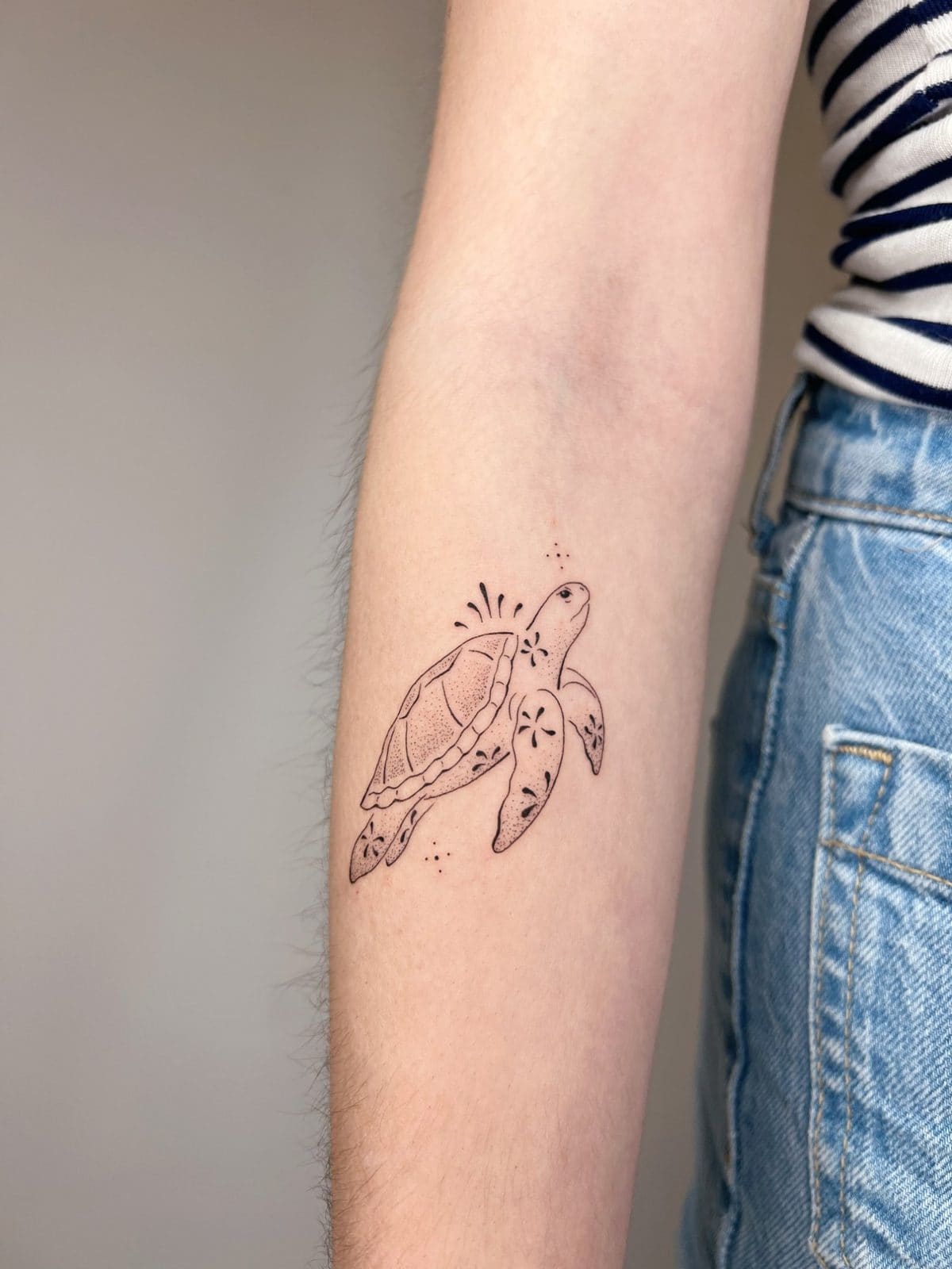 Tortue de mer en fine line et dot work sur l'avant-bras
