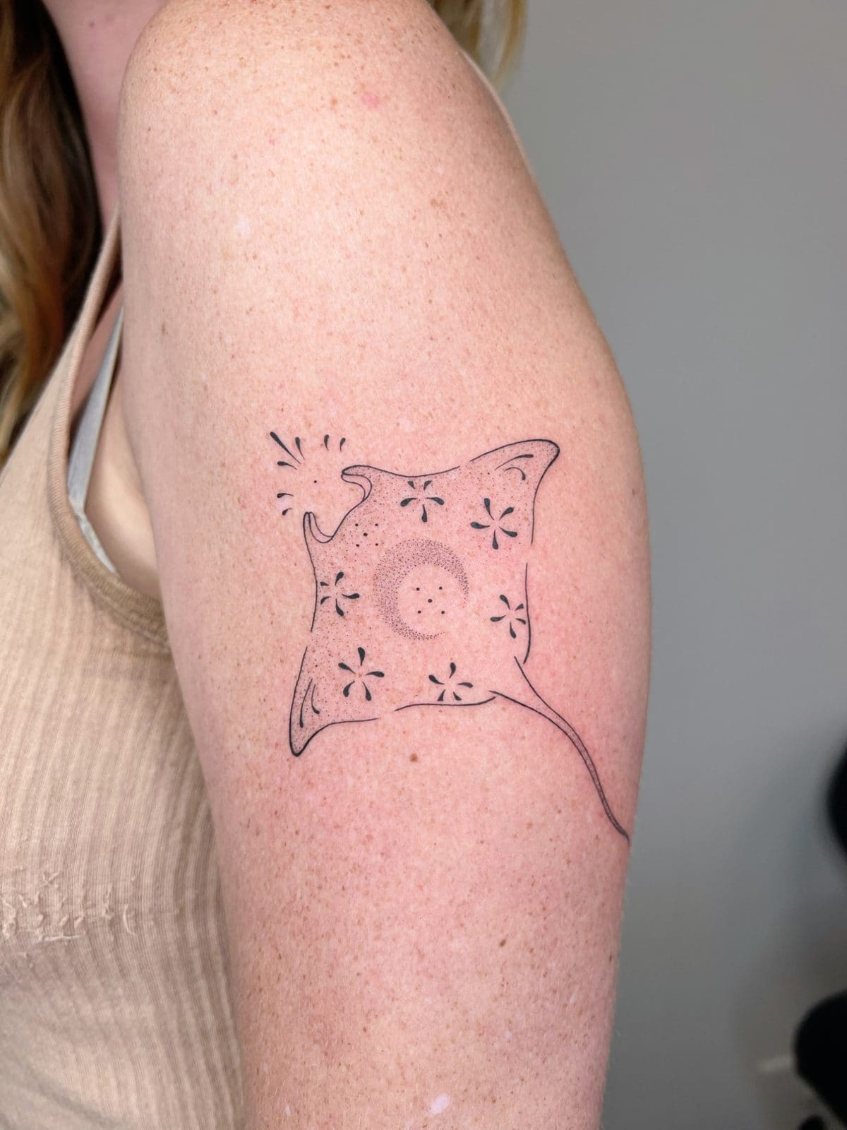 Raie manta en dot work avec fleurs et lune, sur le bras