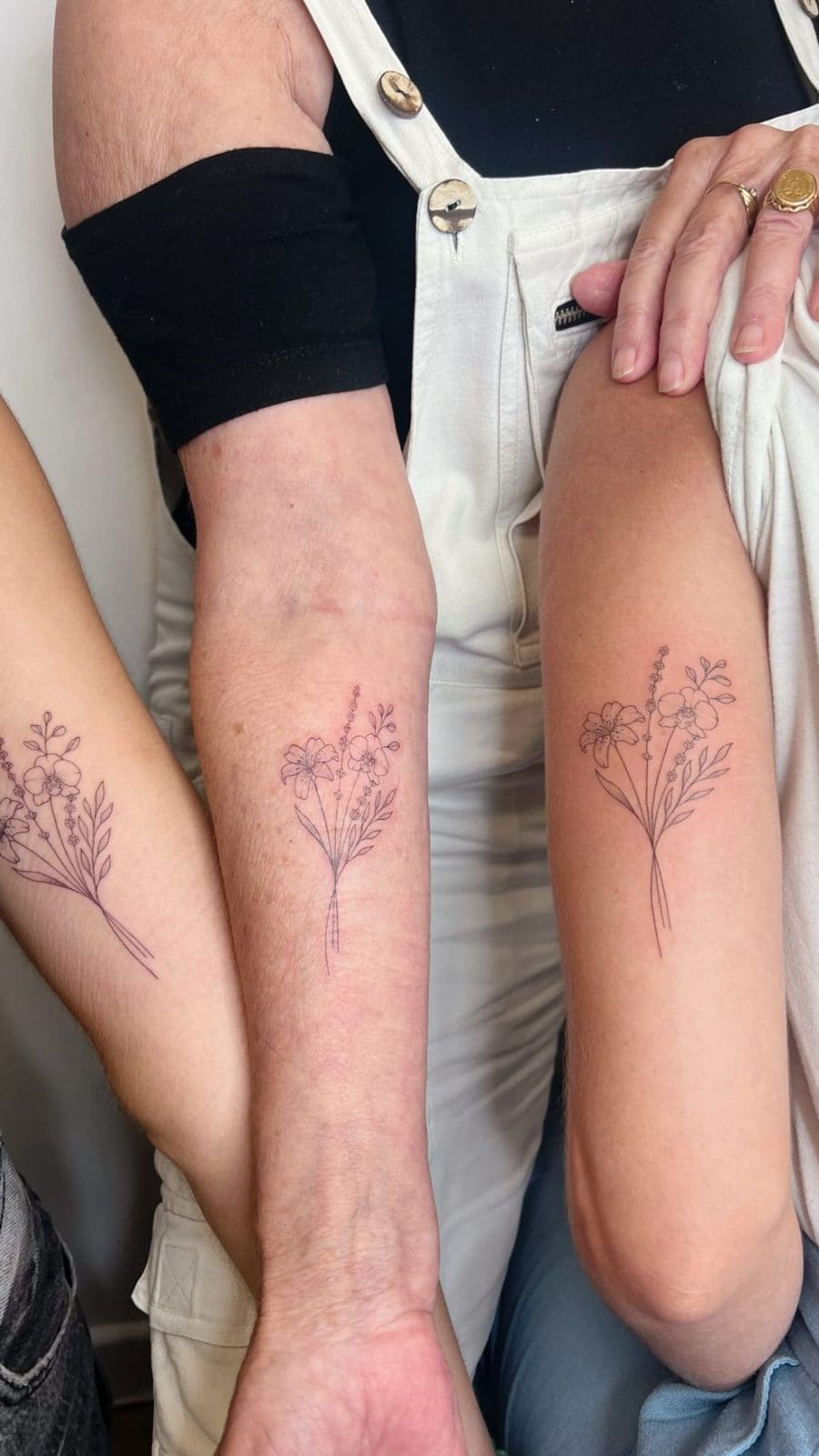 Trois bouquets de fleurs identiques, tatouage matching sur trois avant-bras